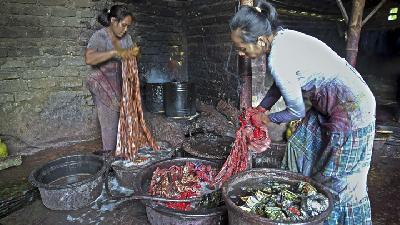 meluruhkan lilin dalam pembuatan kain batik di kampung batik Tanjung Bumi, Bangkalan, Madura, Jawa Timur.