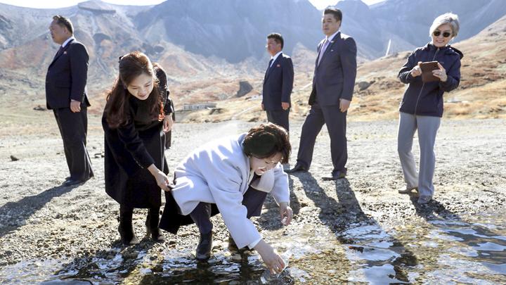 Ibu negara Korea Selatan, Kim Jung-sook (tengah), mengisi botol minummya di Gunung Paektu, Korea Utara, 20 September 2018.