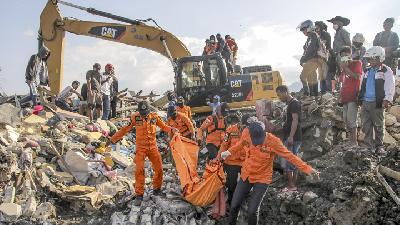 Tim SAR melakukan evakuasi terhadap jenazah korban gempa di Perumahan Nasional Balaroa, Palu Barat. - TEMPO/Muhammad Hidayat