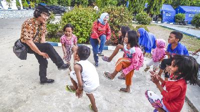 Penyembuhan trauma dengan cara mengajak bermain anak-anak korban gempa tsunami Palu di kantor Dinas Sosial Palu.