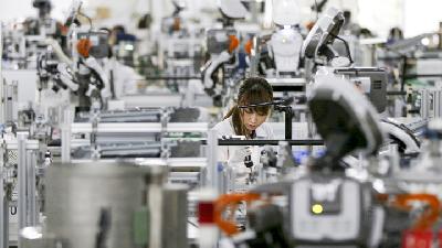 Robot humanoid dan pekerja manusia di salah satu pabrik manufaktur milik Glory Ltd di Kazo, Tokyo, Jepang. 