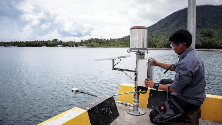 Petugas Badan Meteorologi, Klimatologi, dan Geofisika memasang alat water level di dermaga Pulau Sebesi, Lampung Selatan, Lampung, 1 Januari 2019