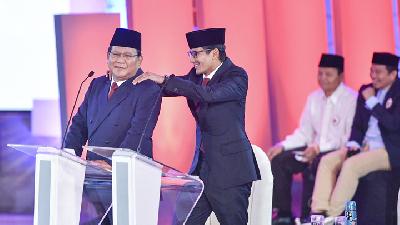 Prabowo Subianto (kiri) dipijat calon wakil presiden pasangannya, Sandiaga Uno, saat jeda debat pertama calon presiden di Hotel Bidakara. ANTARA FOTO