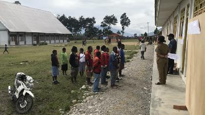 Anak-anak pengungsi bersiap mengikuti ujian sekolah berstandar nasional di sekolah darurat yang meminjam ruangan milik Gereja Kemah Injil Wamena.