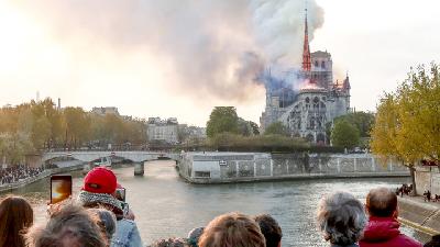 Warga menyaksikan terbakarnya Katedral Notre Dame di Paris, 15 April 2019./Rueters/Benoit Tessier