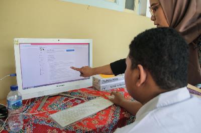 Siswa dan orang tua murid mendaftar seleksi Penerimaan Peserta Didik Baru menggunakan komputer di SMAN 1 Jakarta, Jakarta, Senin lalu.  TEMPO/Muhammad