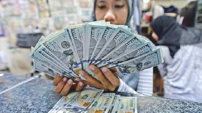 Pegawai menghitung uang dolar Amerika Serikat pecahan 100 di sebuah tempat penukaran mata uang asing (money changer) di Jakarta./TEMPO/Tony Hartawan