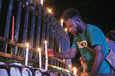 Warga Papua menyalakan lilin saat aksi damai di Bundaran Tugu Perdamaian Timika Indah, Mimika, Papua, kemarin. ANTARA/Sevianto Pakiding