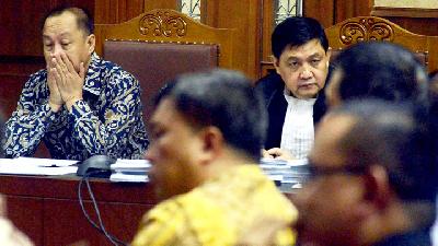 Syafrud­din Arsyad Temenggung (left) and his lawyer, Ahmad Yani, listening to a witness testimony at the Jakarta Corruption Court, July 30, 2018.