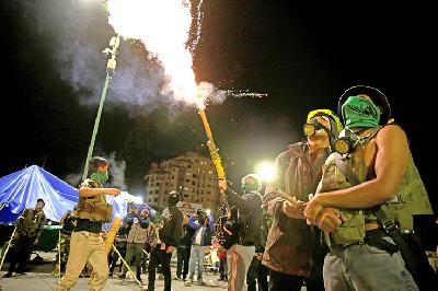 Sekelompok anak muda yang tergabung dalam Cochala menyalakan api untuk merayakan ditunjuknya senator Jeanine Anez sebagai Presiden Bolivia, Selasa lal