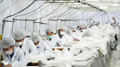 Pekerja membuat baju pelindung di pabrik pakaian di Shijiazhuang, Provinsi Hebei, Cina, 17 Februari lalu./Reuters