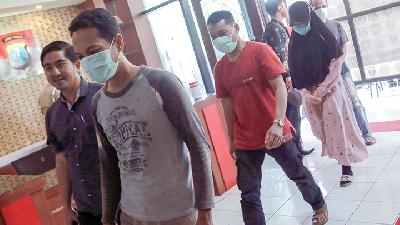 Petugas menggiring empat orang tersangka penyebar berita bohong tentang Covid-19 saat rilis di Mapolres Blitar, Jawa Timur, 18 Maret 2020./ANTARA/Irfan Anshori