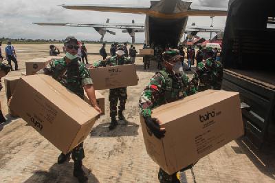 Prajurit TNI AU mengangkat kardus Alat Pelindung Diri (APD) dan masker yang dikirimkan dari Lanud Halim Perdanakusuma Jakarta di Bandara Tjilik Riwut Palangkaraya, Kalimantan Tengah, Sabtu pekan lalu.  ANTARA/Makna Zaezar