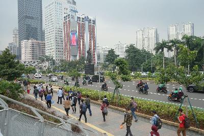Sejumlah karyawan saat jam pulang kerja di jalur pedestrian Jalan Sudirman, Jakarta, 16 Maret lalu.  TEMPO/Muhammad Hidayat