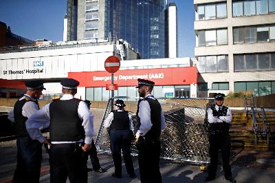 Petugas kepolisian berjaga-jaga di depan rumah sakir St Thomas, London, Inggris, kemarin. REUTERS/Henry Nicholls