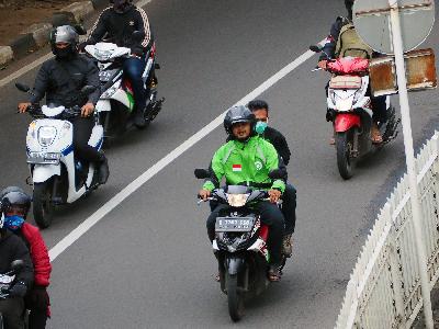 Pengemudi ojek online mengangkut penumpang di kawasan Pondok Indah, Jakarta, kemarin. TEMPO/Nurdiansah