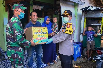 Anggota TNI dan Polri memberikan sembako kepada pemudik yang terdampak COVID-19 di Kudus, Jawa Tengah, kemarin. ANTARA/Yusuf Nugroho