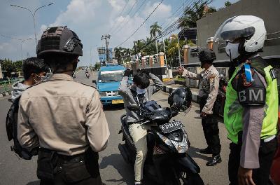 Petugas Polisi meminta pengendara memakai masker saat kegiatan Pengawasan Pelaksanaan PSBB di Jalan Margonda Raya, Kota Depok, Jawa Barat, kemarin. TEMPO/M Taufan Rengganis