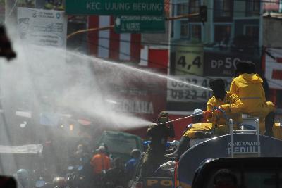Petugas menyemprot cairan disinfektan di ruas jalan nasional depan Pasar Ujungberung, Bandung, Jawa Barat, kemarin. TEMPO/Prima Mulia