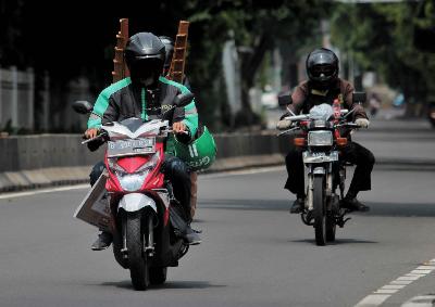 Pengemudi ojek online mengantar pesanan pelanggan di Jalan Panjang, Jakarta Barat, kemarin. TEMPO / Hilman Fathurrahman W