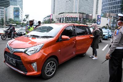 Polisi meminta penumpang mobil berpindah ke kursi bagian belakang saat pemeriksaan kepatuhan Pembatasan Sosial Berskala Besar di kawasan Bundaran HI, Jakarta, Senin lalu. ANTARA/Hafidz Mubarak A