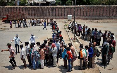 Pekerja migran dan tuna wisma antre saat pembagian makanan gratis di Ahmedabad, India, kemarin. REUTERS/Amit Dave