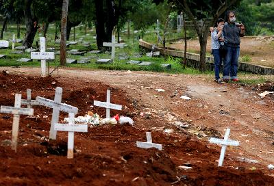 Kelurga dari korban Covid-19 menyaksikan pemakaman di Taman Pemakaman Umum Pondok Ranggon, Jakarta, 3 April lalu. REUTERS/Willy Kurniawan