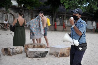 Petugas meminta wisatawan untuk meninggalkan kawasan pantai saat melakukan patroli di Pantai Kedonganan, Badung, Bali, 15 April lalu. ANTARA/Fikri Yusuf