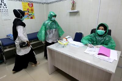 Petugas medis Puskesmas Ulee Kareng memakai jas hujan plastik sebagai alat pelindung diri (APD) saat melayani pasien di Banda Aceh, Aceh, 8 April lalu. Antara/Irwansyah Putra