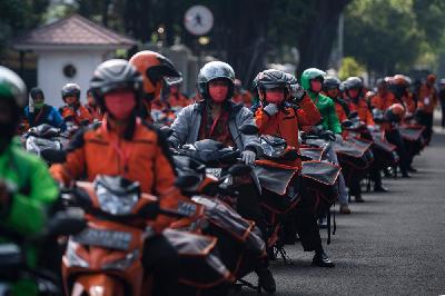 Pegawai POS Indonesia dan ojek daring bersiap mendistribusikan bantuan sosial sembako di depan Istana Merdeka, Jakarta, Senin lalu. ANTARA/Sigid Kurniawan