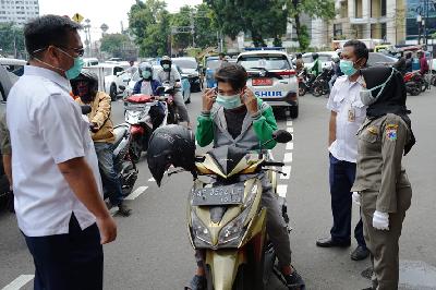 Pemeriksaan terhadap pengendara yang melintas saat Pembatasan Sosial Berskala Besar (PSBB) di Jalan Proklamasi, Jakarta, 15 April lalu.  TEMPO/Muhammad Hidayat
