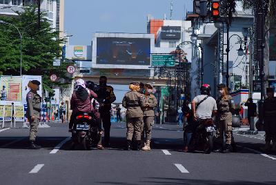 Petugas menahan pengendara sepeda motor yang menerobos kawasan ring 1 saat pemberlakuan PSBB Bandung Raya di kawasan pusat Kota Bandung, Jawa Barat, kemarin. TEMPO/Prima Mulia