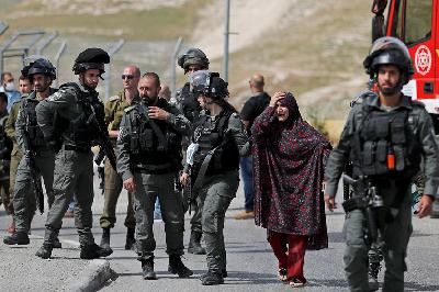 Pasukan Israel menahan ibu dari warga Palestina yang melakukan penyerangan di dekat pemukiman Yahudi Maale Adumim, Tepi Barat,  Israel, 22 April lalu. REUTERS/Ammar Awad