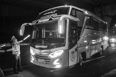 Polisi menghalau mobil bus yang membawa pemudik di tol Jakarta-Cikampek untuk keluar ke Gerbang tol Cikarang Barat, Kabupaten Bekasi, Jawa Barat, kemarin. ANTARA/Fakhri Hermansyah
