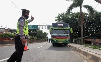 Polisi menghentikan bus penumpang saat penerapan larangan mudik di Jalur Pantura, perbatasan Kabupaten Bekasi dengan Karawang, Kabupaten Bekasi, Jawa Barat, Sabtu lalu.