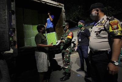 Petugas gabungan menyerahkan bantuan kebutuhan pokok dari Pemprov DKI Jakarta  kepada warga yang terkena dampak Covid-19 di  Kebon Kacang, Jakarta, 12 April lalu. 