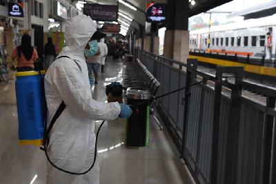 Petugas Satgas COVID-19 Kota Malang menyemprotkan cairan disinfektan di area stasiun Kota Baru Malang, Jawa Timur, 19 Maret lalu. TEMPO/Aris Novia Hidayat