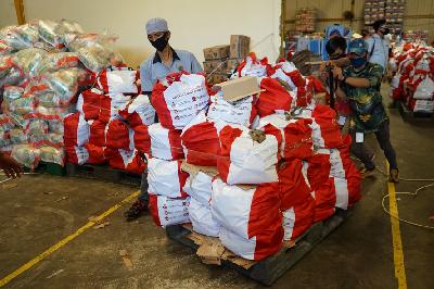 Pekerja membawa paket bantuan bahan kebutuhan pokok untuk warga terdampak COVID-19 di Food Station Tjipinang Jaya, Jakarta, 22 April lalu. TEMPO/Muhammad Hidayat