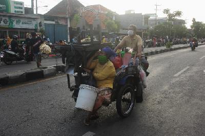 Pedagang mengangkut peralatannya di pasar tumpah saat pemberlakuan pembatasan sosoal berskala besar di Tembok Dukuh, Surabaya, Jawa Timur, kemarin. 