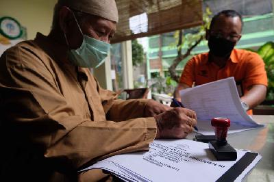 Petugas Kantor Pos Indonesia memberikan data warga penerima paket bantuan sosial dari Presiden RI sebelum didistribusikan kepada warga terkena dampak Covid-19 di kawasan Pasar Minggu, Jakarta Selatan, Selasa lalu.  