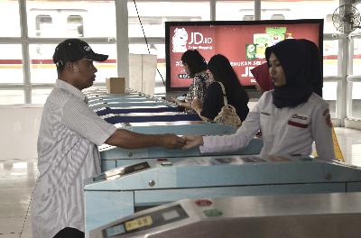 Petugas commuter line membantu penumpang menggunakan kartu elektronik di Stasiun Tebet, Jakarta, 2018. Dok TEMPO/Fakhri Hermansyah