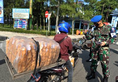 Anggota TNI AU menghentikan pengendara sepeda motor yang tak gunakan masker di Nurtanio, Bandung, Jawa Barat, 9 April lalu. TEMPO/Prima Mulia
