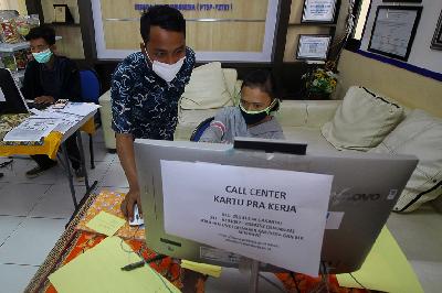 Petugas mendampingi warga yang melakukan pendaftaran calon peserta Kartu Prakerja di Surabaya, Jawa Timur, 13 April lalu. ANTARA/Moch Asim