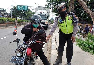 Polisi memeriksa pengendara sepeda motor saat penerapan pelarangan mudik di jalur Pantura, perbatasan Kabupaten Bekasi dengan Karawang, Kabupaten Bekasi, Jawa Barat, kemarin. 