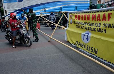 Personel TNI memeriksa sejumlah pengendara sepeda motor yang akan melewati titik pemeriksaan pada hari pertama PSBB di Kabupaten Gowa dan kota Makassar, Sulawesi Selatan, Senin lalu. 