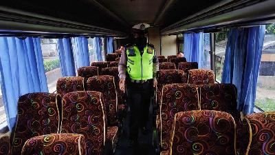 Polisi memeriksa bagian dalam bus penumpang saat penerapan pelarangan mudik di Jalur Pantura, Perbatasan Kabupaten Bekasi dengan Karawang, Jawa Barat, 25 April 2020. TEMPO / Hilman Fathurrahman W