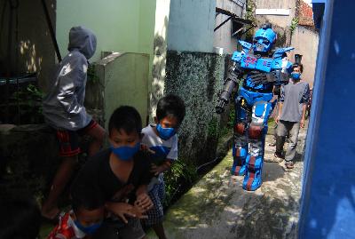 Anak-anak berlarian saat relawan karang taruna berkostum robot melakukan patroli pembatasan soisal di Sekepanjang, Bandung, Jawa Barat, 7 Mei 2020. TEMPO/Prima Mulia