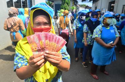 Pekerja menunjukkan uang Tunjangan Hari Raya (THR) Lebaran yang diterimanya di pabrik rokok PT Djarum, Kudus, Jawa Tengah, 12 Mei 2020. ANTARA/Yusuf Nugroho