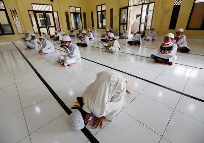 Siswa membaca Alquran dengan protokol pembatasan jarak di Masjid Daarul Qur'an Al Kautsar, Bogor, Jawa Barat, 9 Mei 2020. REUTERS/Willy Kurniawan