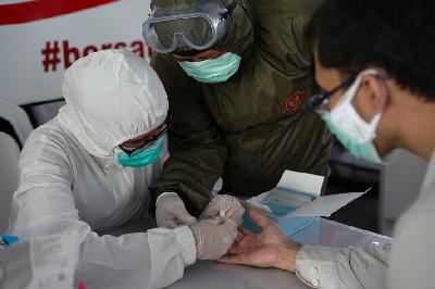 Petugas medis melakukan pemeriksaan cepat atau rapid test COVID-19 saat tes massal di Terowongan Kendal, Jakarta, 6 Mei 2020.  TEMPO/Muhammad Hidayat